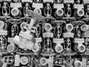 A black-and-white photo showing a grid of identical industrial valves from Smith Valves, with one valve positioned diagonally while the others are aligned uniformly, creating a striking visual contrast.